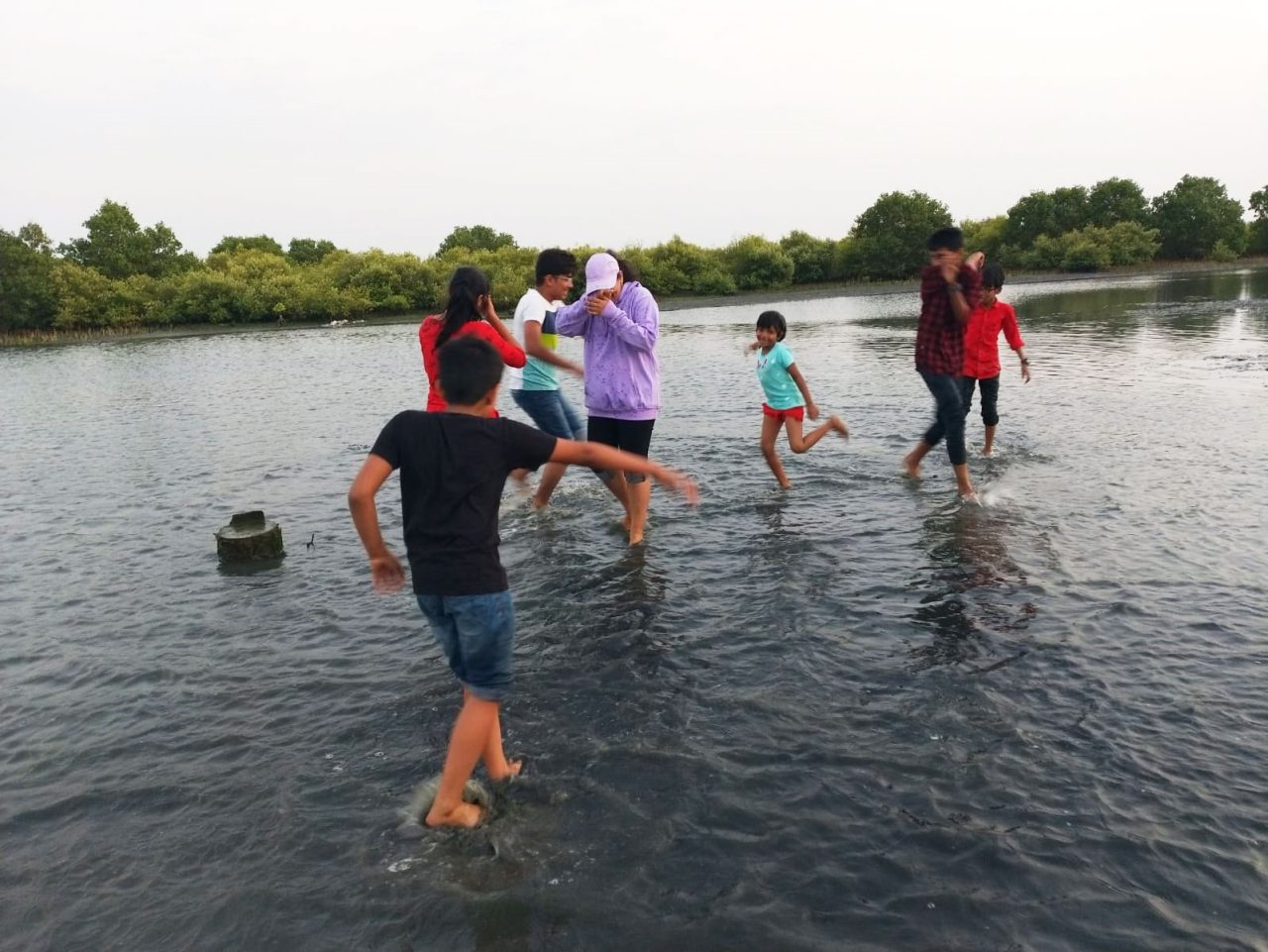 Guests walking in shallow water near Aamees Paradise